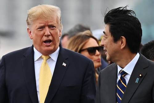 El presidente de EU, Donald Trump, conversa con el primer ministro de Japón, Shinzo Abe, cuando abandona el barco de la armada japonesa, en Yokosuka.Foto Afp