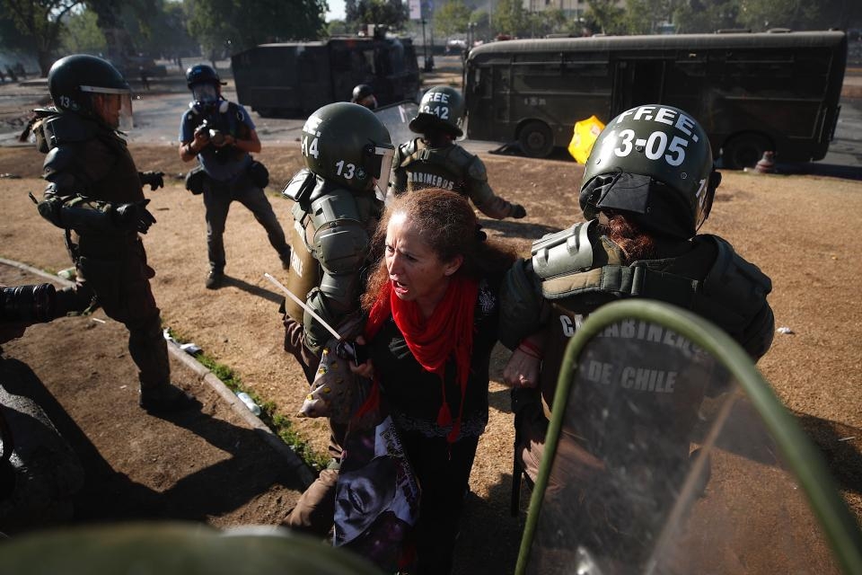 Una manifestante es llevada detenida por la policía chilena en Santiago. ________________________________________ Imagen: EFE
