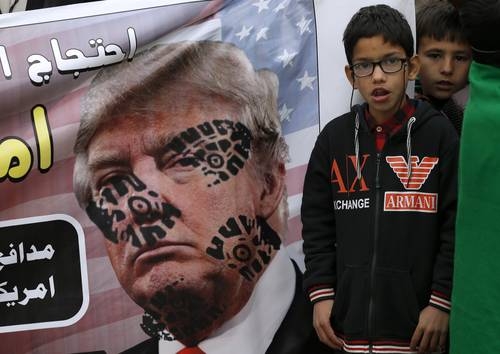 Niños al lado de un cartel con la imagen profanada del presidente Donald Trump escuchan un discurso de condena a Estados Unidos por haber ordenado el asesinato del general iraní Qasem Sulaimani, en una manifestación en Pakistán.Foto Ap