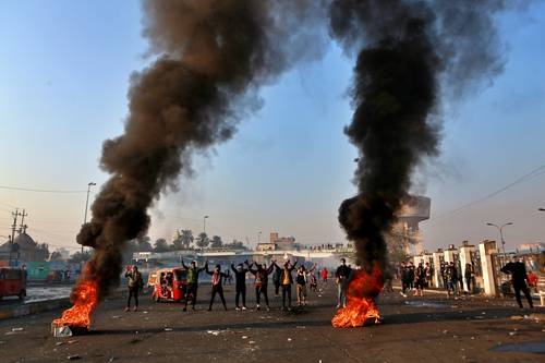 Manifestantes cierran las calles mientras las fuerzas de seguridad usan gases lacrimógenos durante una protesta en el centro de Bagdad, Irak.Foto Ap