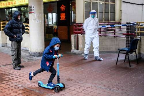 Un niño juega afuera de un edificio en Hong Kong que fue desalojado debido a casos de infección por coronavirus.Foto Afp