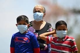 Una mujer y dos niños con mascarilla en Jiquilisco, municipio de El Salvador.MARVIN RECINOS / AFP