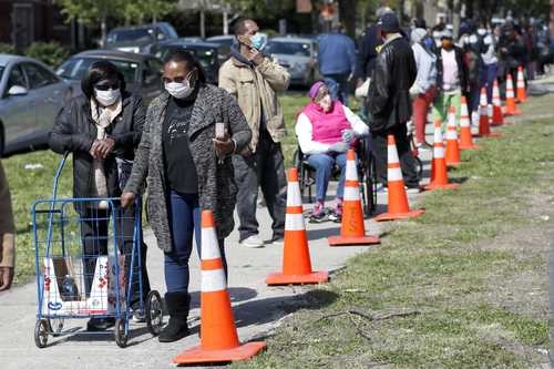 Personas hacen fila para recibir comida en el Gran Depósito de Alimentos de Chicago, en el barrio Auburn Gresham.Foto Ap