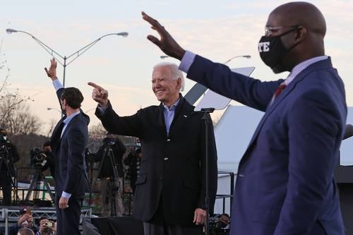El presidente electo Joe Biden (al centro) se reunió ayer con los candidatos demócratas para el Senado de Estados Unidos, Jon Ossoff (a la izquierda) y Raphael Warnock, en Atlanta, Georgia.Foto Afp