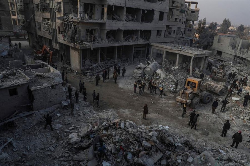 Foto de archivo (09/01/2018) de civiles y voluntarios de la Defensa Civil Siria mientras buscan supervivientes después de que varios ataques aéreos en Hamoria, al-Ghouta (Siria). — MOHAMMED BADRA / EFE