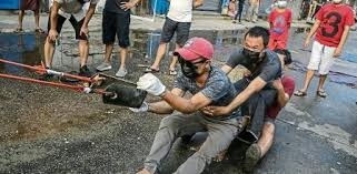 Unos activistas prueban una especie de gran cauchera sujeta a un poste, ayer en Rangún