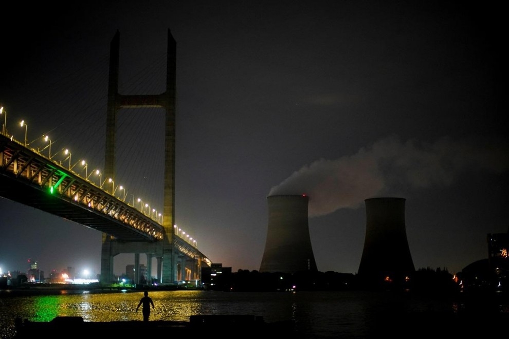 Un hombre camina a la orilla del río Huangpu cerca de una central eléctrica de carbón en Shanghai, China. — Aly Song / REUTERS