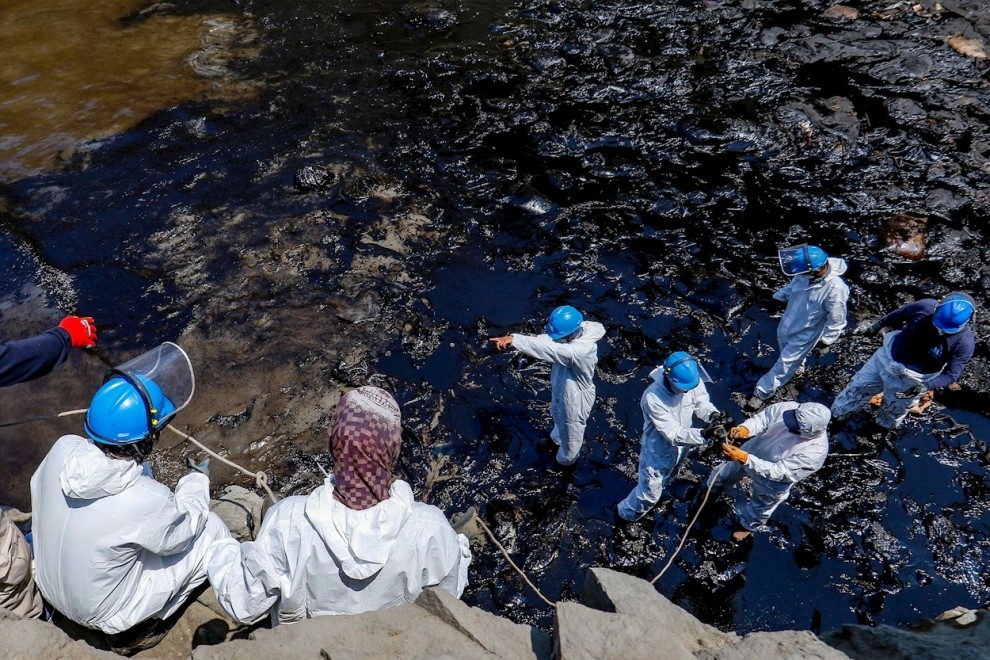 Varios operarios trabajan en labores de limpieza del petróleo derramado en las costas peruanas por la refinería de La Pampilla operada por Repsol. — Cristhian Meza / EFE