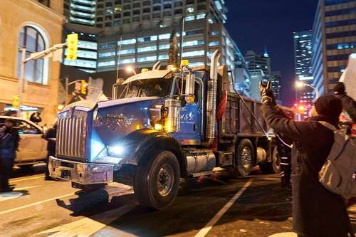 Unos 50 mil camioneros canadienses, integrantes del convoy de la libertad, rechazan las medidas restrictivas por el covid-19. En la imagen, la policía permite el paso a uno de los manifestantes en Toronto, capital de la provincia de Ontario.Foto Afp