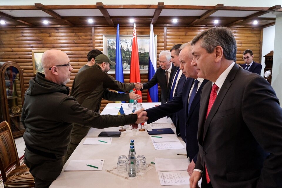 Representantes de Rusia y Ucrania se dan la mano antes de empezar la segunda ronda de negociaciones.. Imagen: AFP