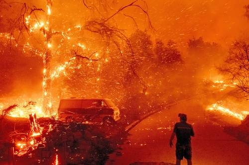 Un habitante observa cerca de su casa el Bond Fire, incendio forestal que devastó más de 2 mil 700 hectáreas en Santiago Canyon, del condado de Orange, California, en diciembre de 2020.Foto Ap