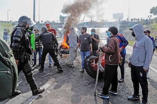 Policías antimotines intentan levantar un bloqueo carretero en la ruta al aeropuerto de Sucre, Ecuador, en el quinto día de protestas sociales por el costo de la vida.Foto Afp